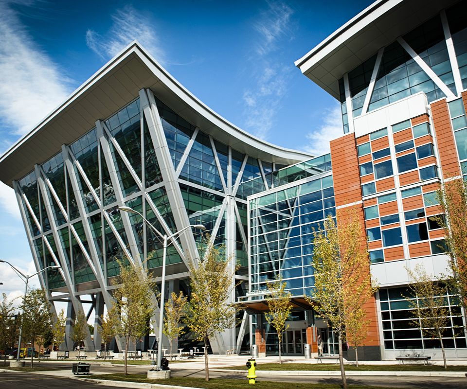 Contemporary glass-and-steel building with a sweeping curved roof.