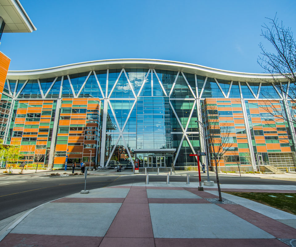 The modern architectural design of the Aldred Centre with large glass windows and a distinctive geometric structure.