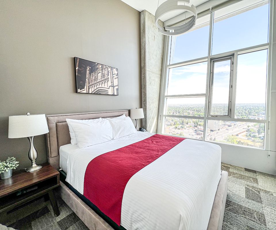 Bright modern hotel bedroom with a neatly made bed.