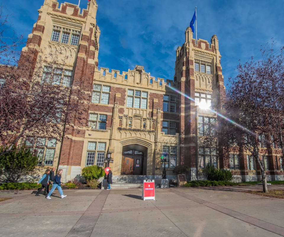 Historic university building with decorative architecture and students walking by.