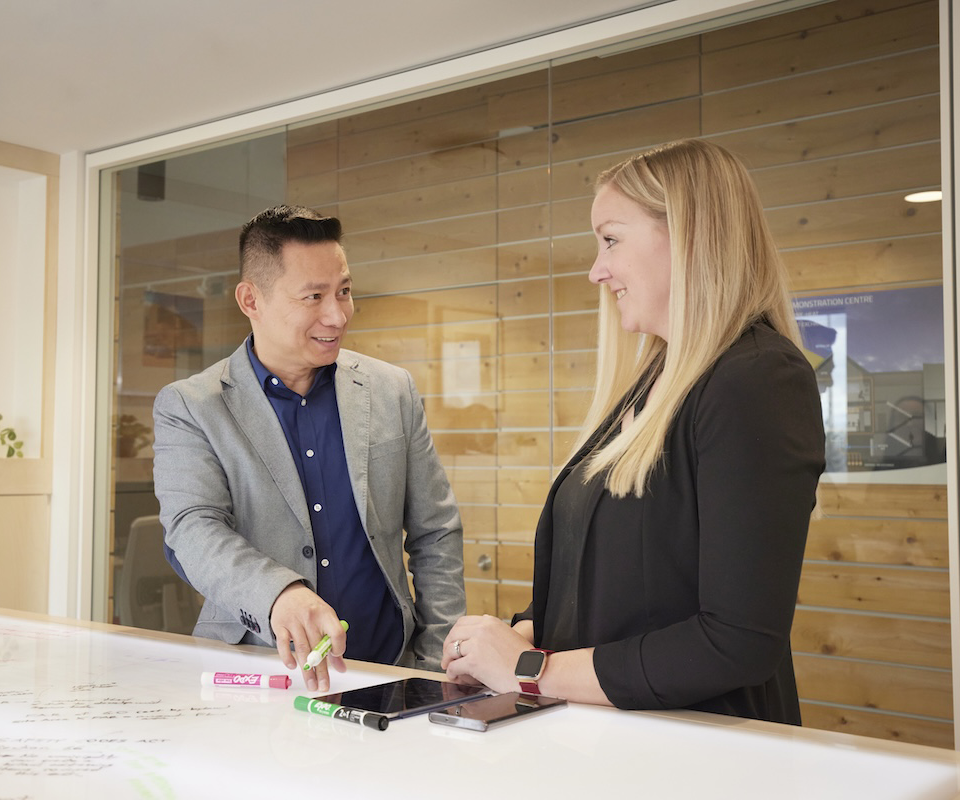 Two professionals discussing a document in a modern office setting
