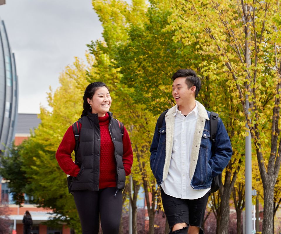 man and woman walking outside in autumn weather