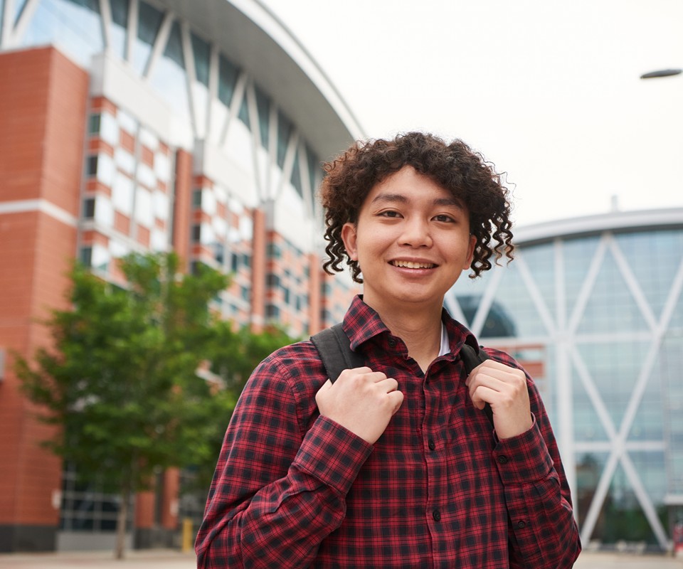 Student standing on SAIT campus, smiling at the camera.