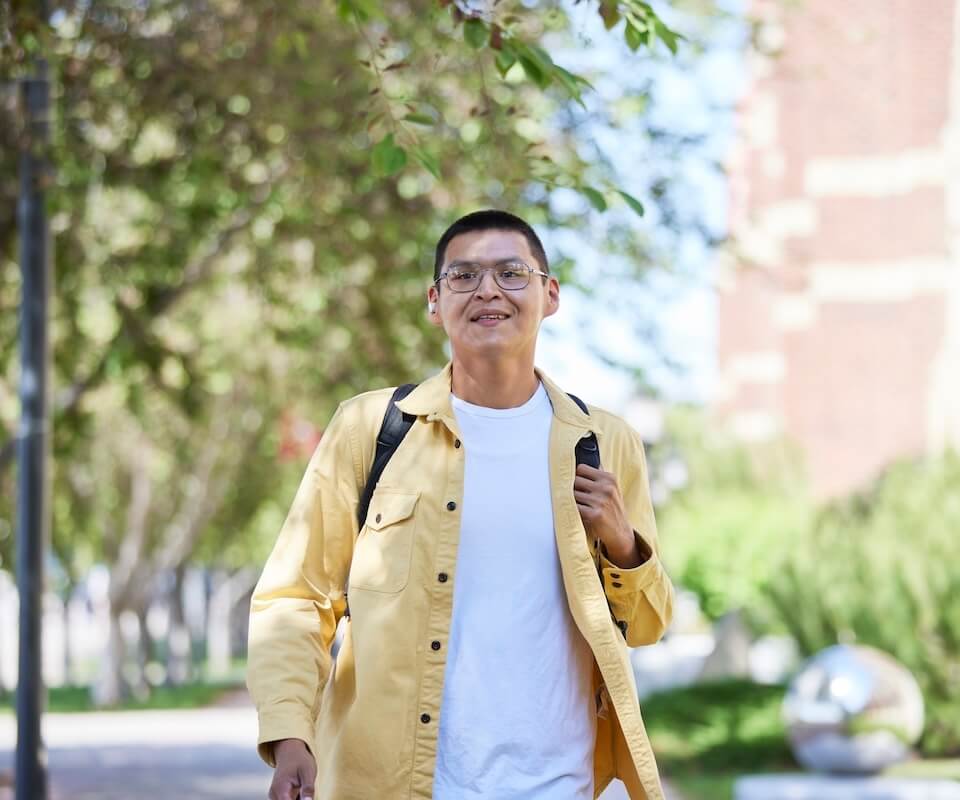 A student walking in front of Heritage Hall
