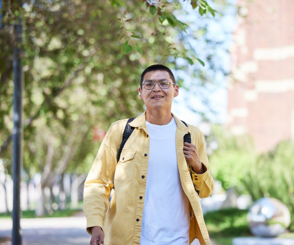 student walking through campus with backpack