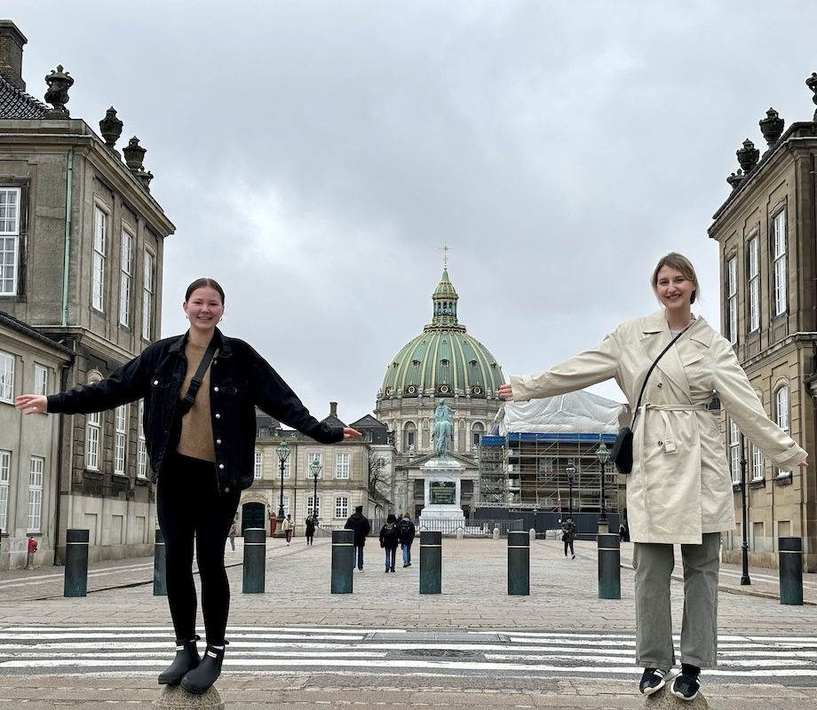 Two students standing in front of a historic building