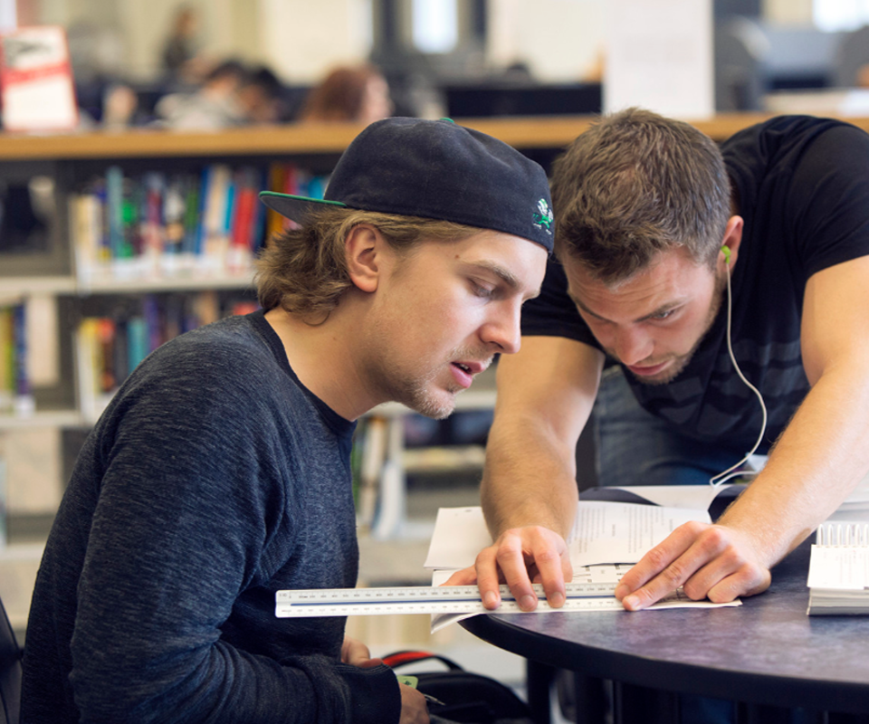 Two apprentices work on homework in the library.