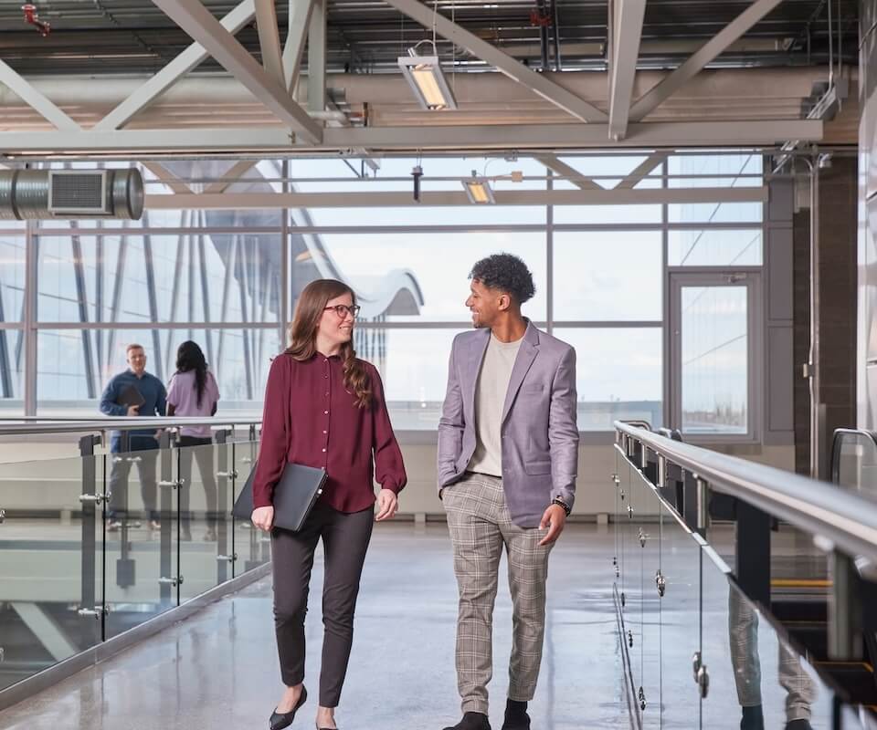 Two people walking in a hallway