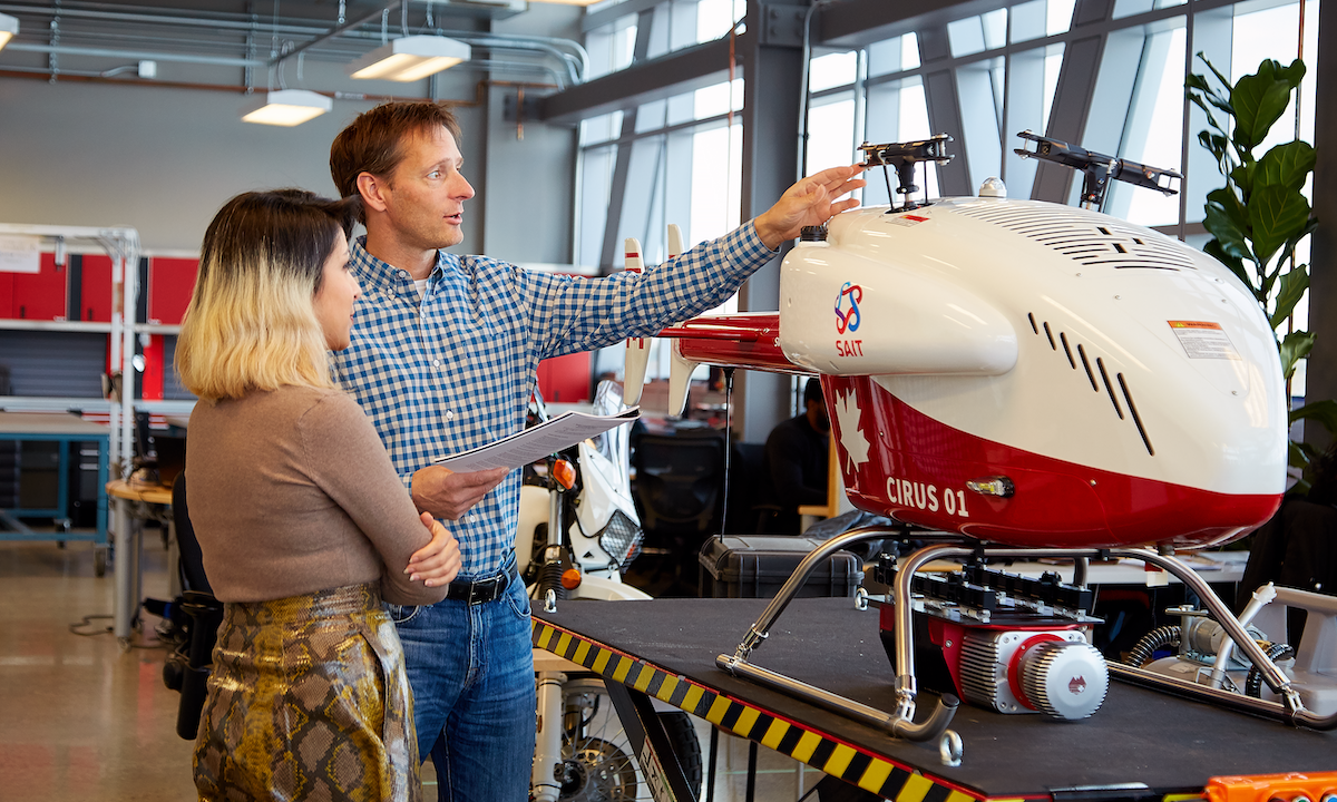 An instructor and student working on a drone