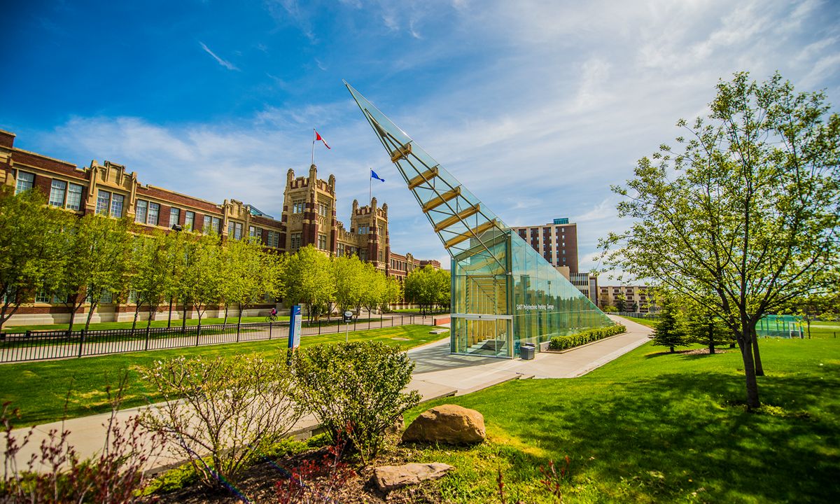 Modern glass pavilion set against a historic building with flags