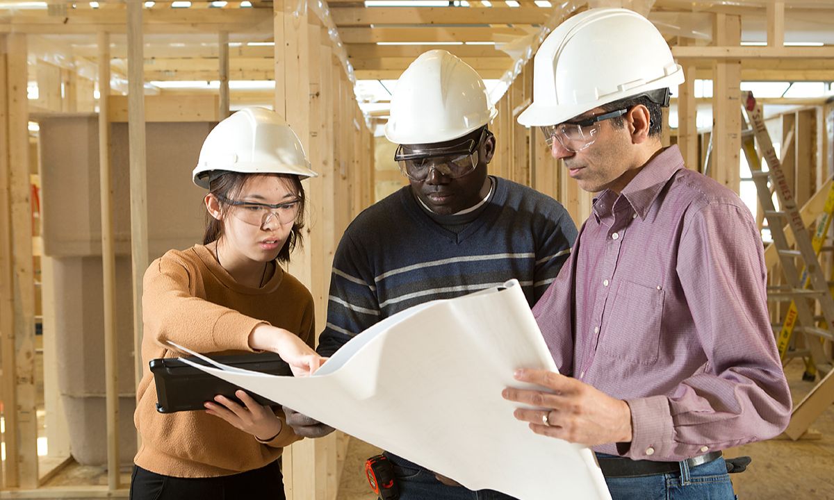 construction team reviewing plans inside frame building