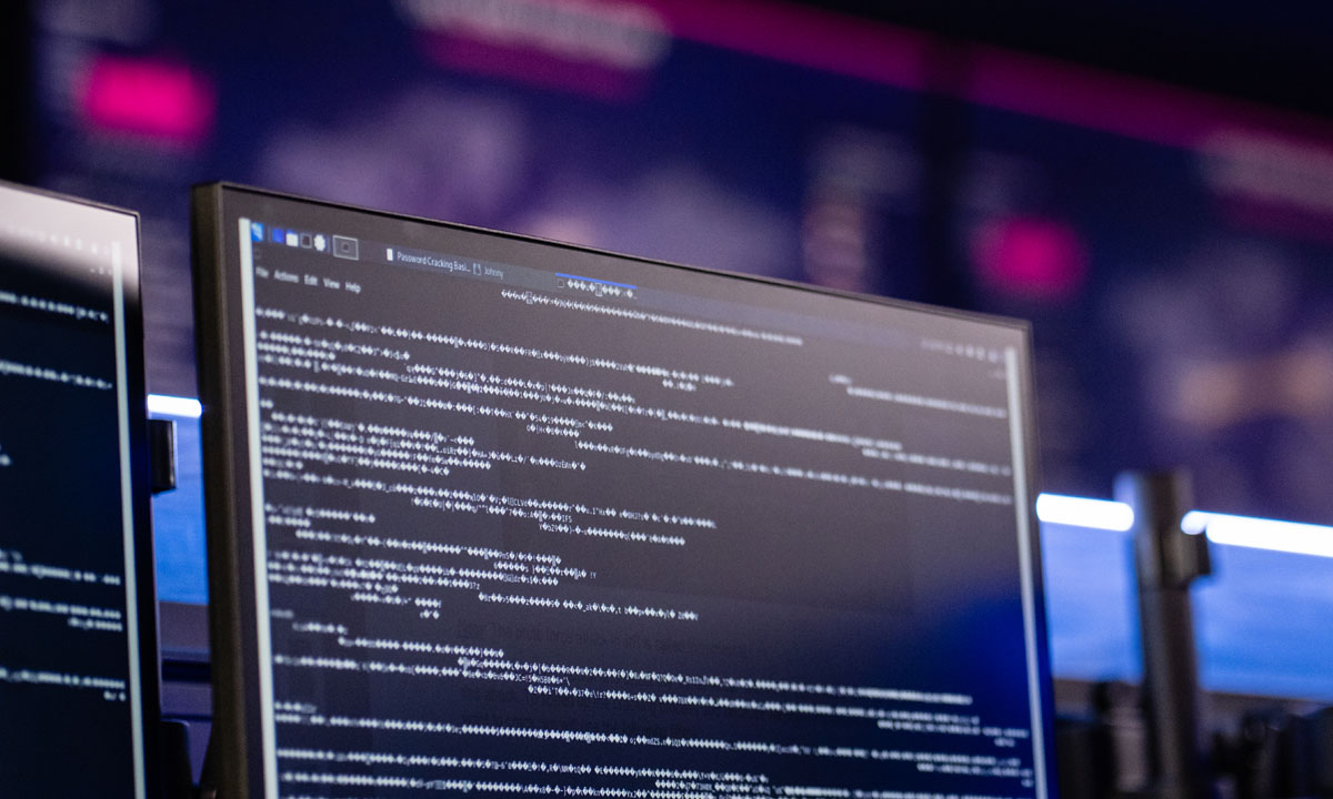 A close-up of a computer screen displaying lines of code and data on a tech-themed background.