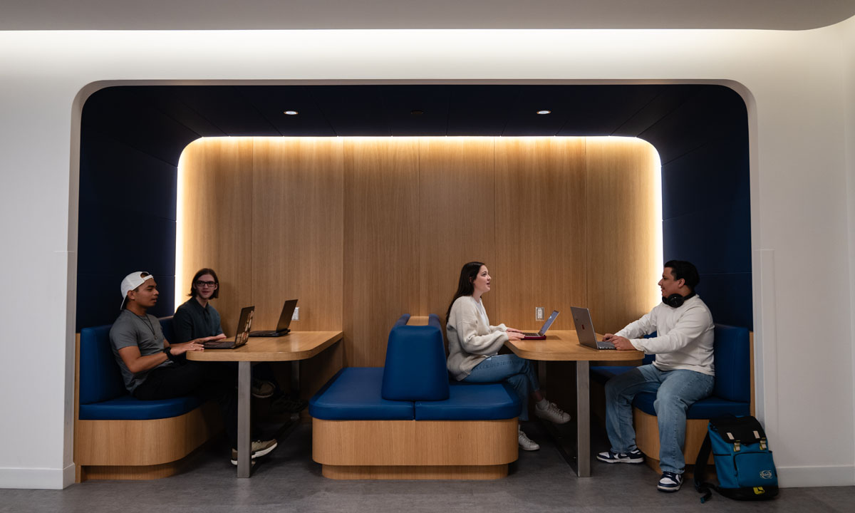 Students engaged in group study at modern workstations, utilizing laptops in a well-lit space, at SAIT Downtown campus.
