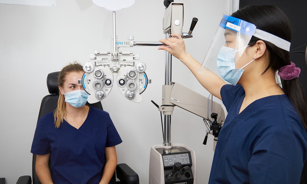 eye exam with phoropter by medical staff in clinic