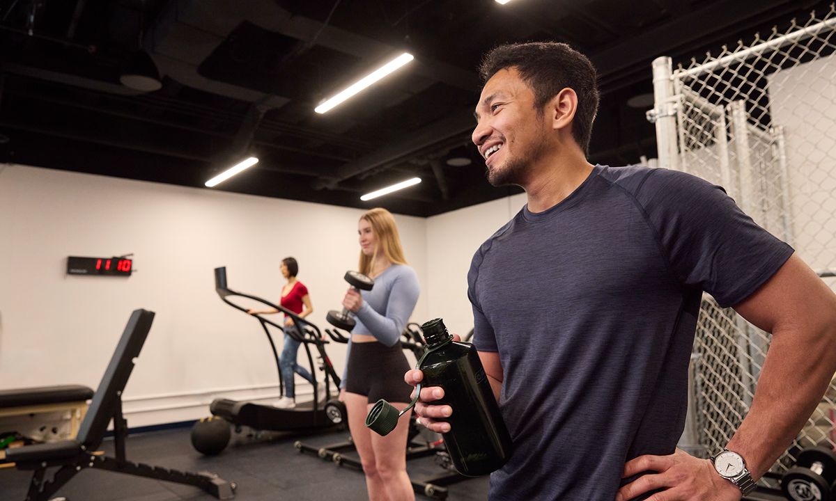 group exercise in gym smiling participant with water bottle