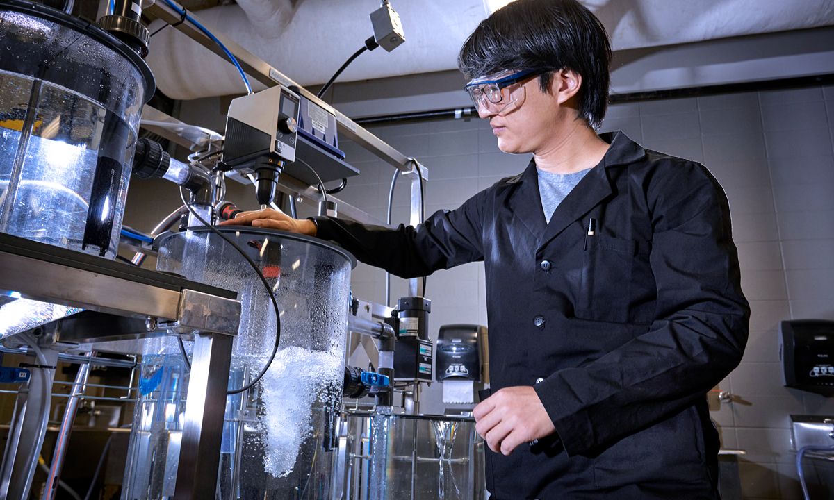 man in blue lab coat operating machine