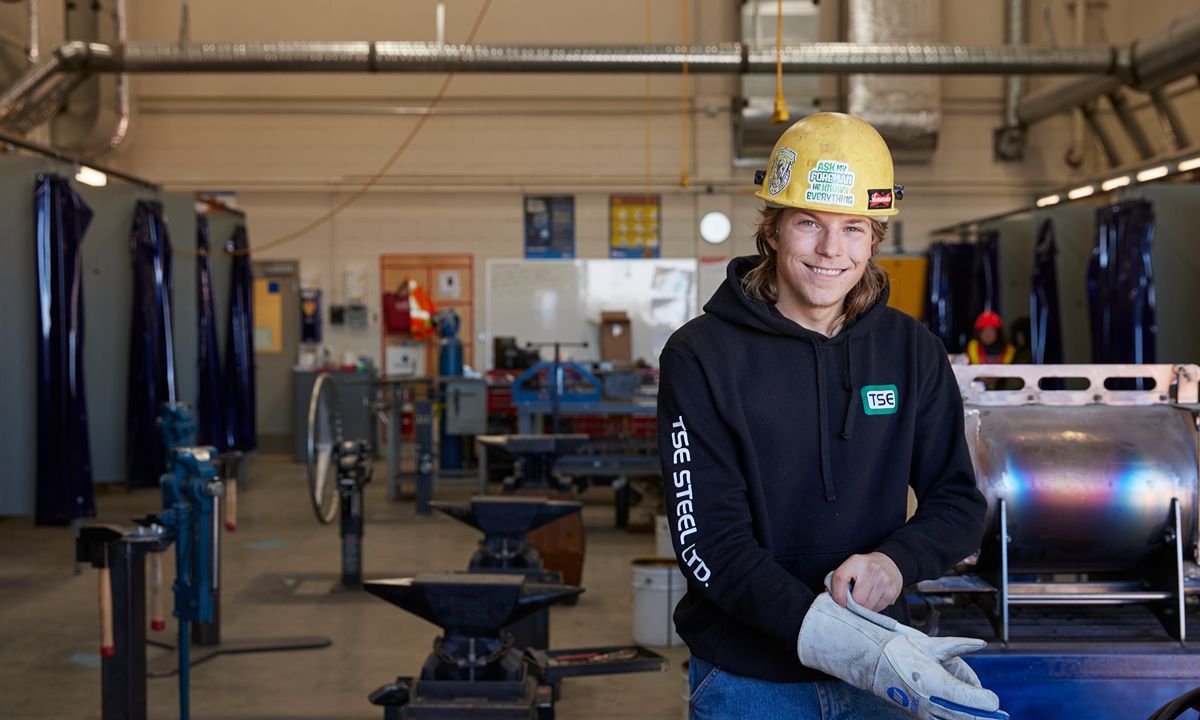 metalworker in yellow hard hat and hoodie