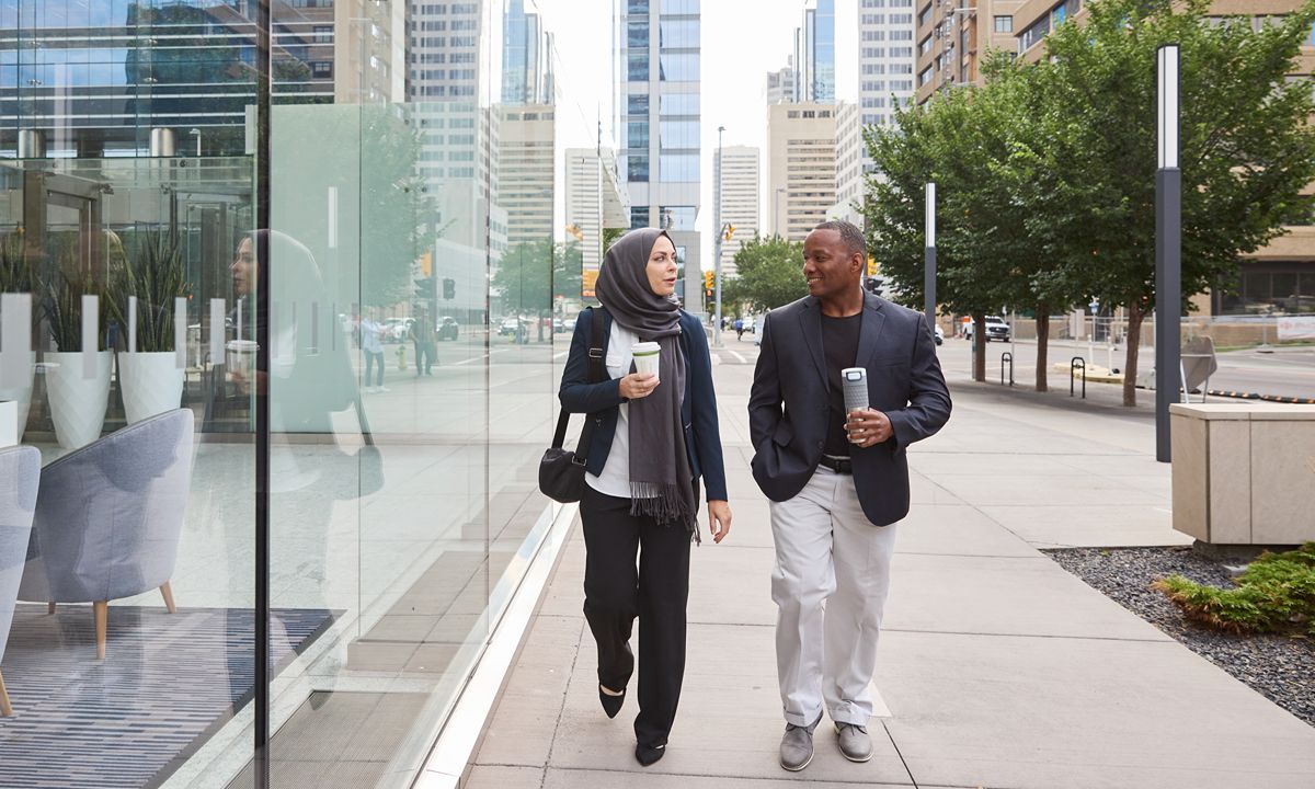 people walking with coffee in city setting