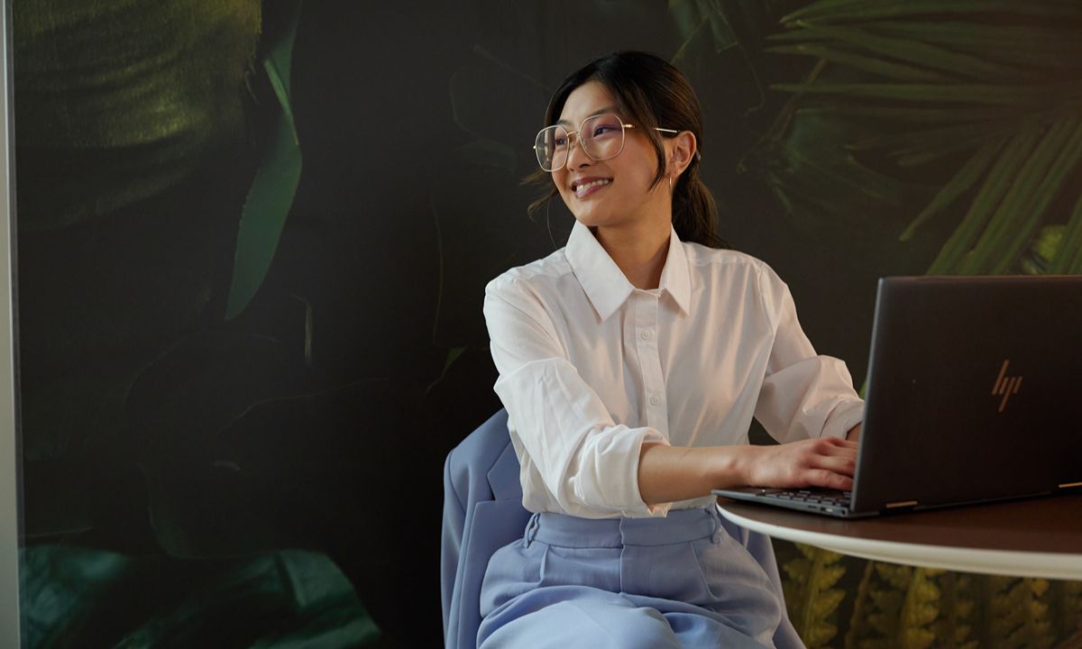 person at round table using laptop white shirt blue pants