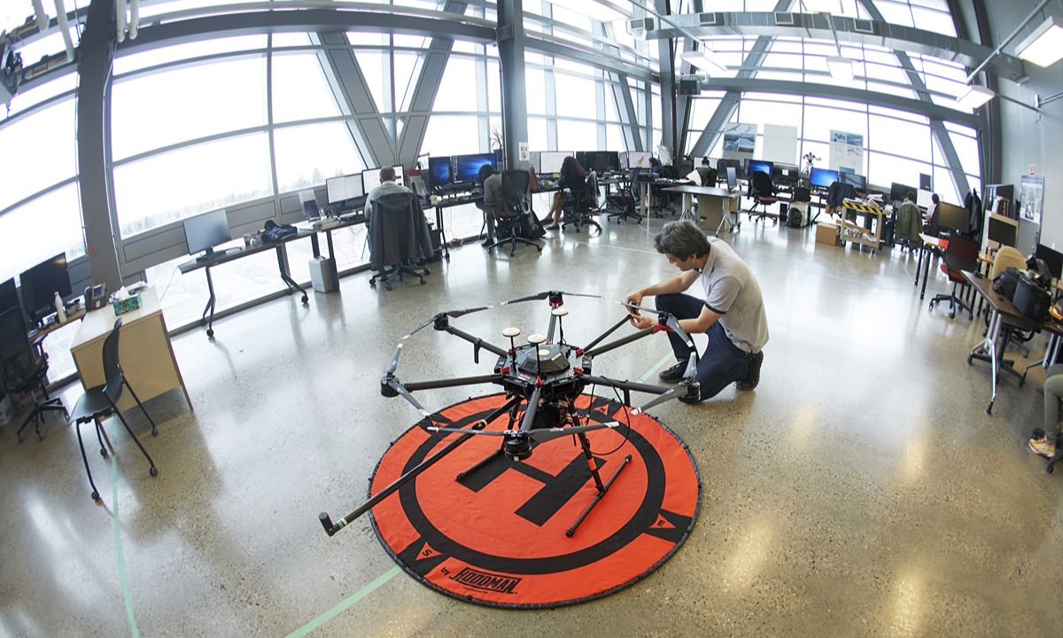 person preparing large drone on a landing pad