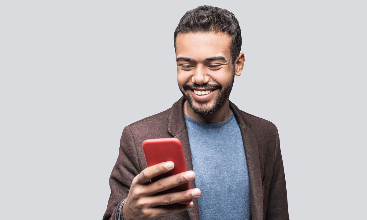person smiling at red smartphone