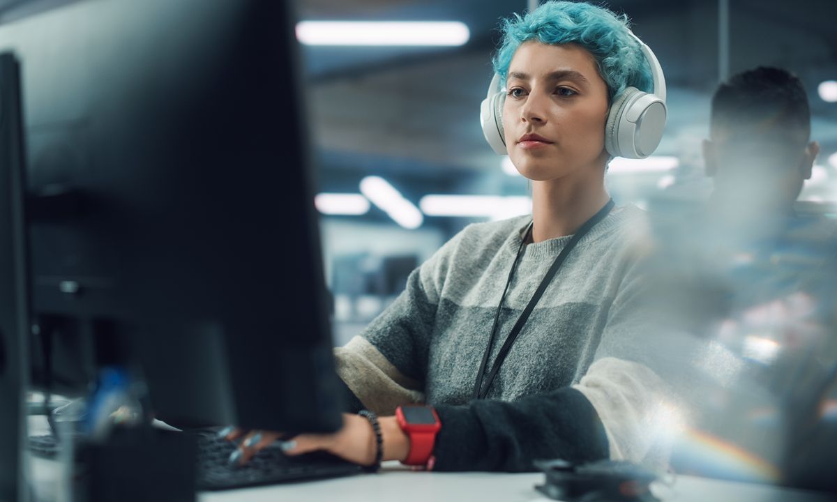 person with headphones working on computer