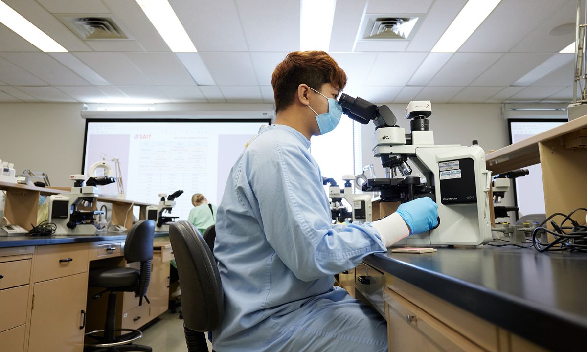 scientist using microscope in lab