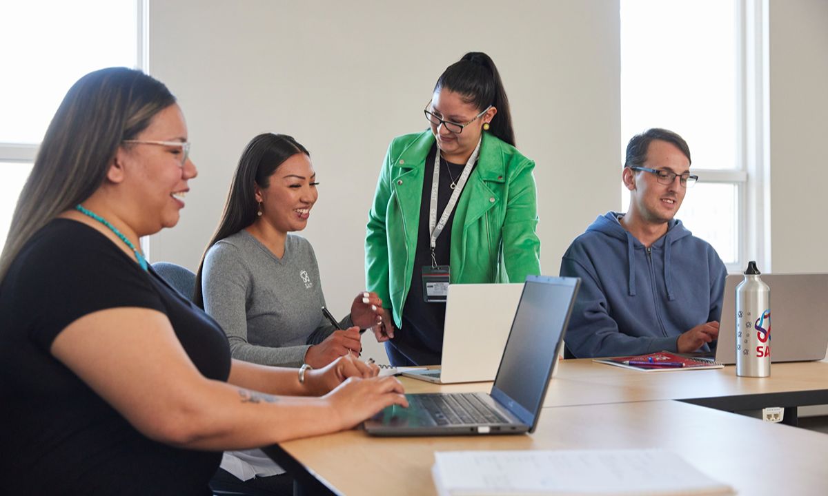 team discussion around laptops in office