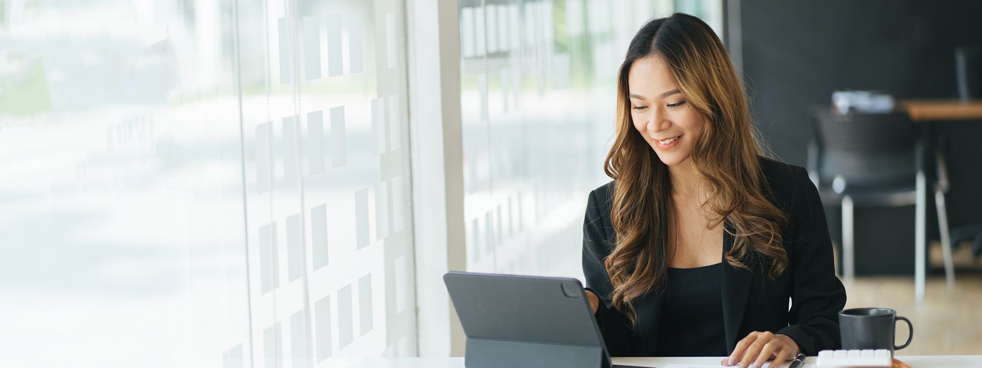 person using tablet at desk with docs books coffee