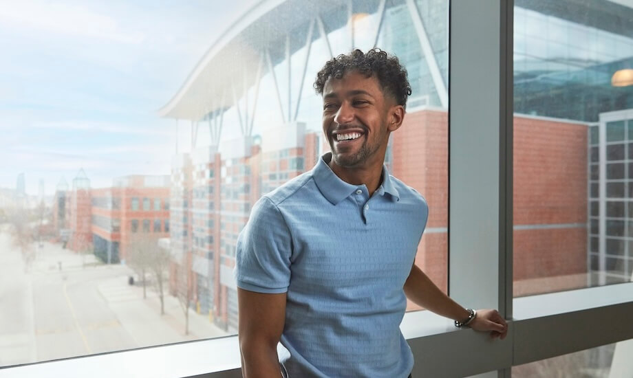 A man standing inside with a SAIT building behind him