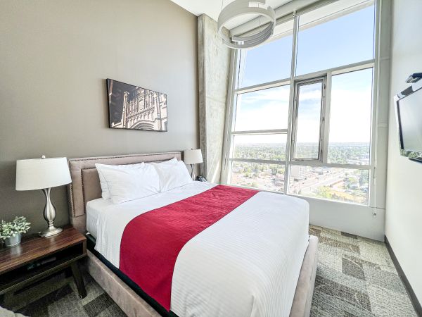 Bright modern hotel bedroom with a neatly made bed.
