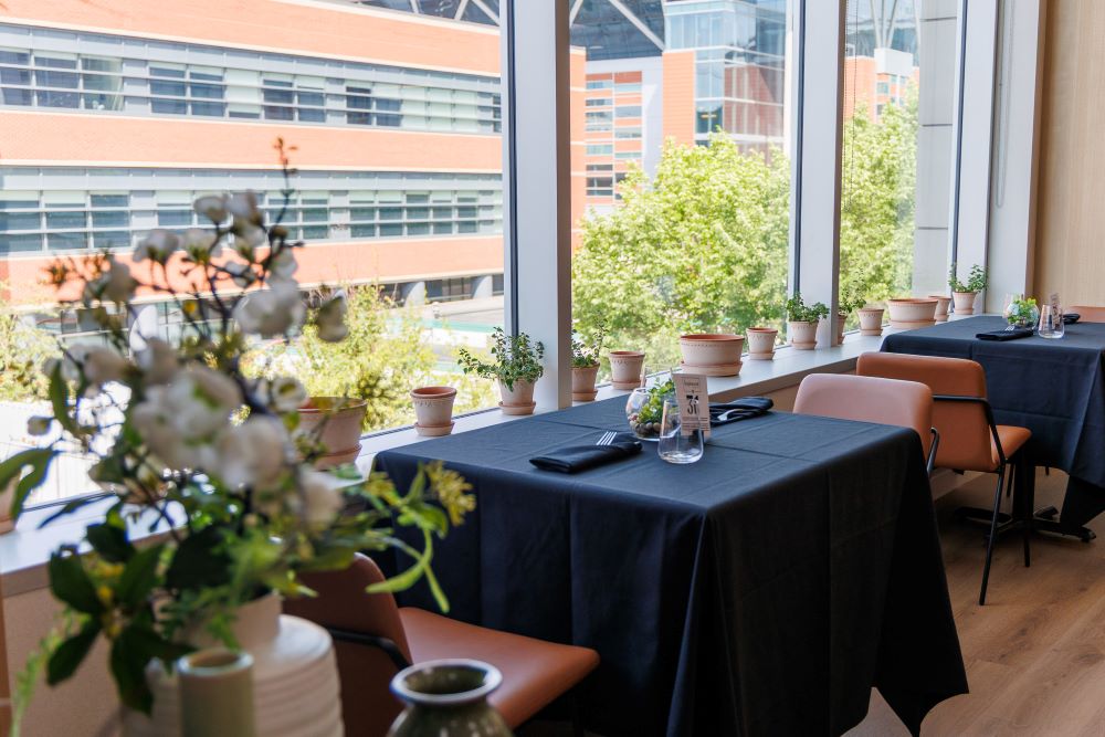 A bright restaurant setting featuring tables with black tablecloths