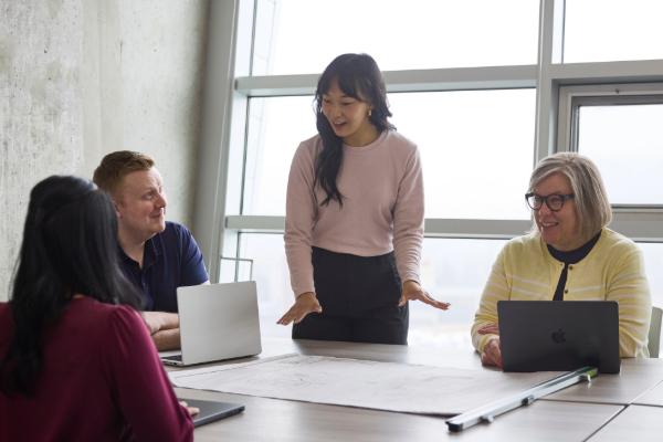 A group of engineers sit around a boardroom table, talking.
