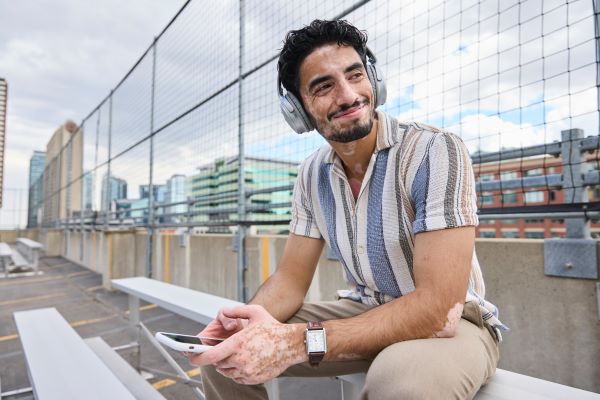 Person sitting on outdoor bleachers wearing headphones