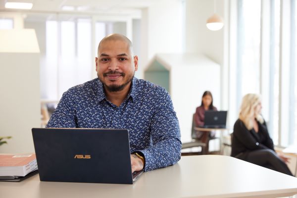 Person working on a laptop at an office desk.