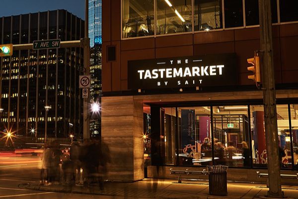 Street view of The Tastemarket by SAIT illuminated at night