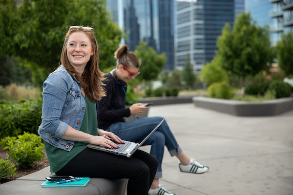 Two students sitting outside in the summer