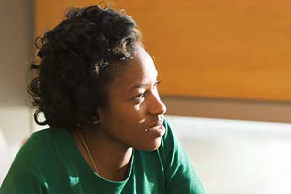 Women in a green shirt looks away from the camera