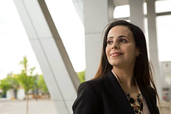 A women looks to the right of a the camera. She is smiling.