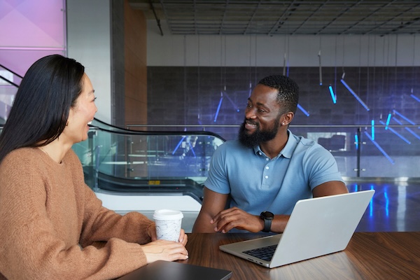 Two people sitting at a table talking.