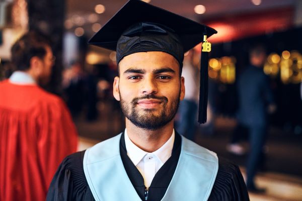 Person in a graduation gown looking at the camera