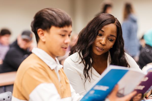 A women and a man reading a book together 