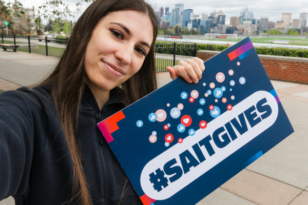 One student holding up a Giving Day sign