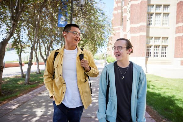 Two men talking to each other while walking