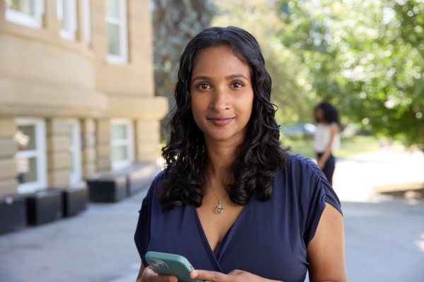 A woman gazing into the camera while holding a phone