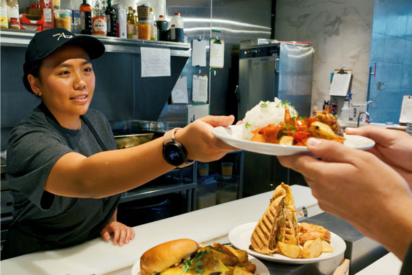 A woman handing a plate of food to a person