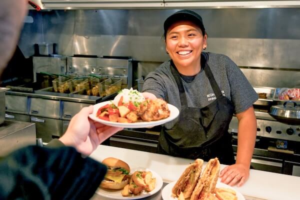 Chef handing a student a plate of food 