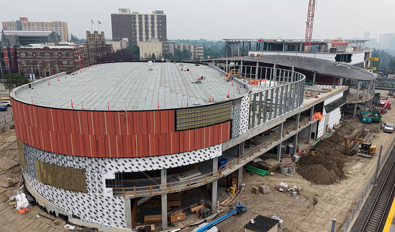 Taylor Family Campus Centre construction site with SAIT's Heritage Hall and Senator Burns building in the background and the gym under construction in the foreground.