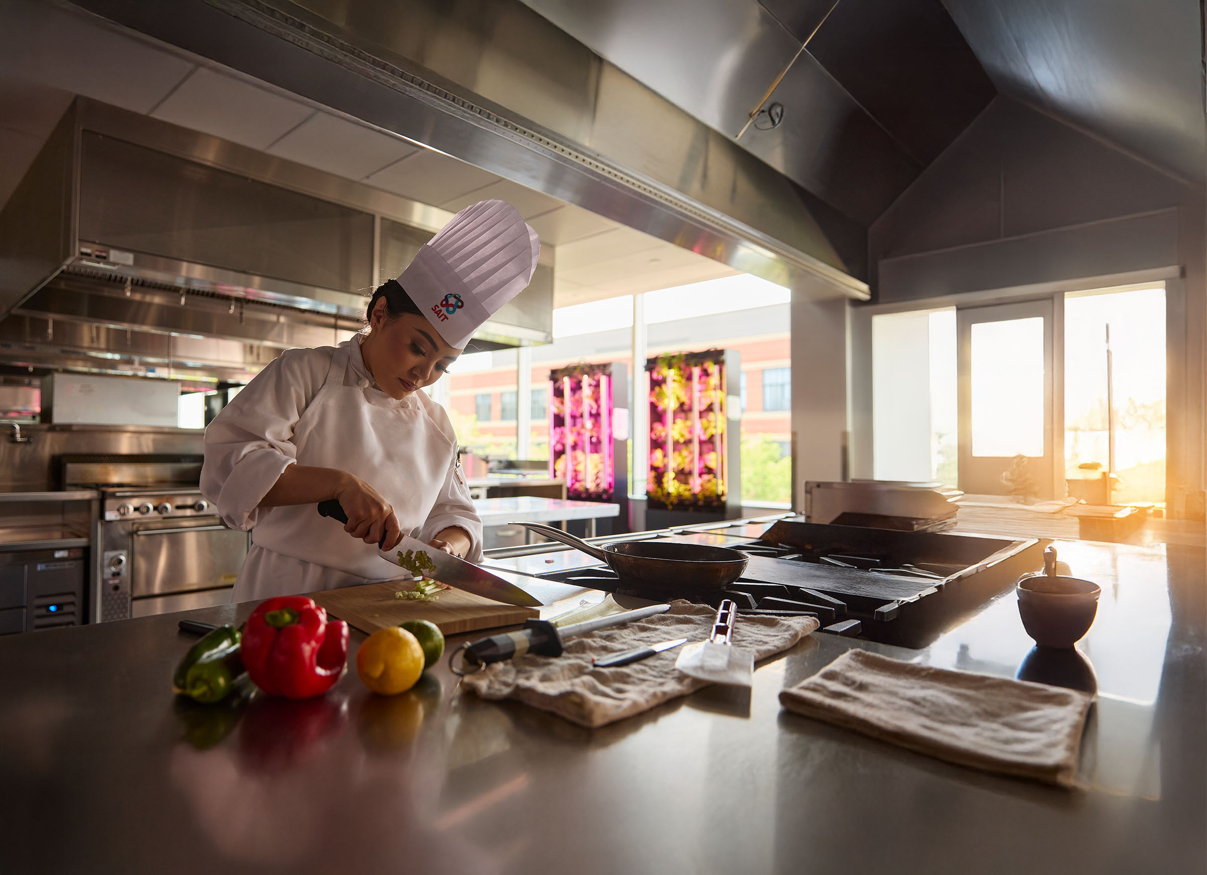young female chef in the kitchen chopping vegetables