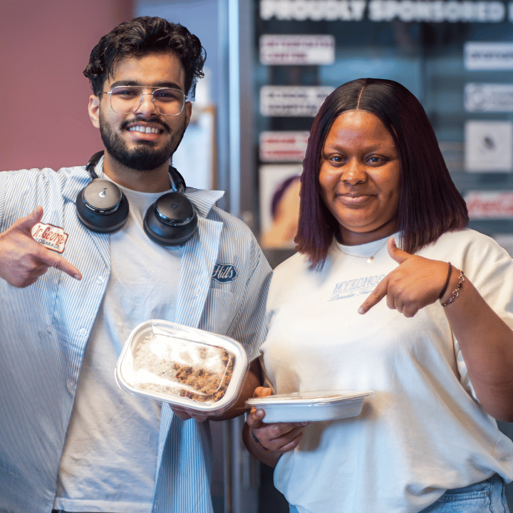 students and partner chef standing in front of fridge.